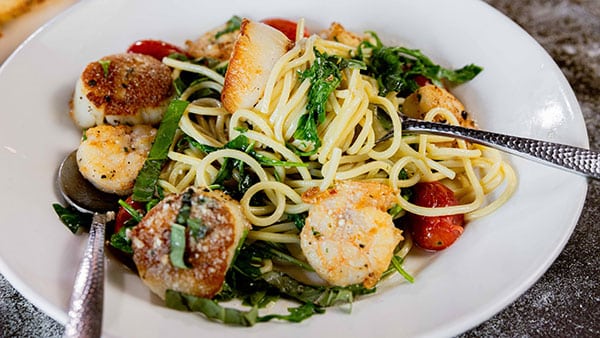 Seafood pasta dish with shrimp, scallops, cherry tomatoes, and fresh herbs served in a white bowl at The Bistro at Gervasi Vineyard.