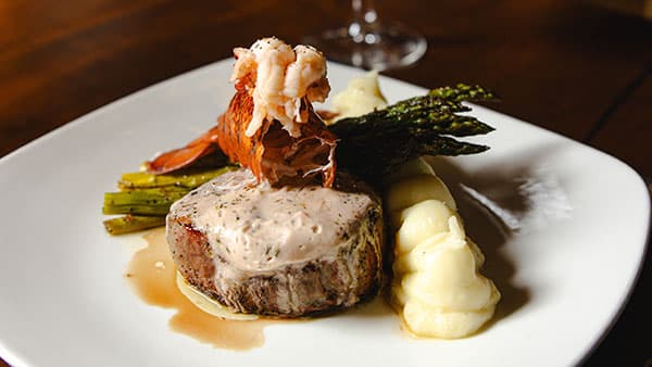 Filet mignon topped with lobster and herb cream sauce, served with mashed potatoes and grilled asparagus at Gervasi Vineyard’s Bistro restaurant.