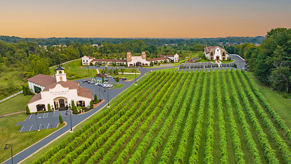 Aerial view of Gervasi Vineyard estate showcasing lush vineyard rows, The Villa Grande, and surrounding Tuscan-inspired buildings
