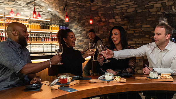 Friends enjoying wine and charcuterie in the intimate Wine Cave at Gervasi Vineyard.