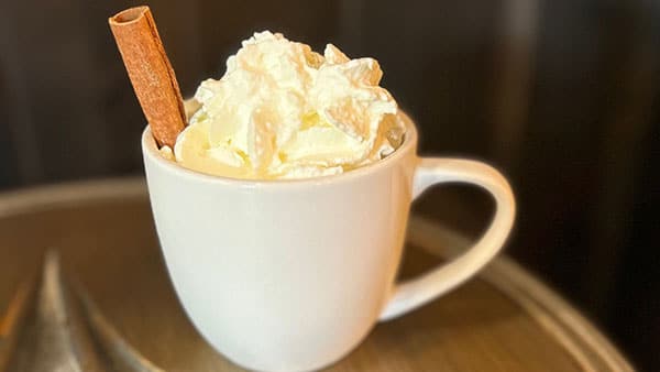 Warm fall beverage topped with whipped cream and a cinnamon stick served at Gervasi Vineyard during seasonal events.