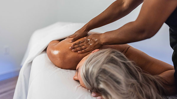 Woman receiving a relaxing shoulder massage at The Spa at Gervasi Vineyard, showcasing personalized wellness treatments in a serene environment.