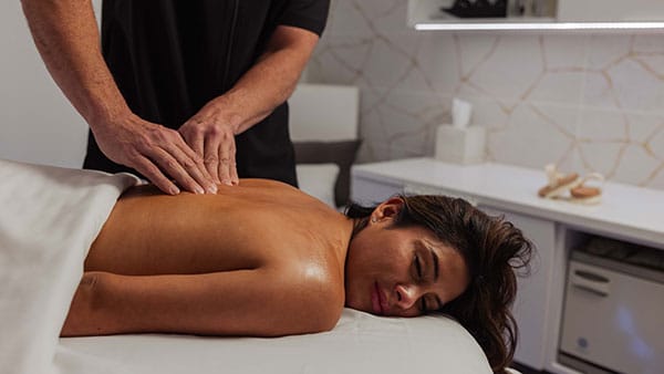 Guest receiving professional back massage in the tranquil treatment room at The Spa at Gervasi Vineyard