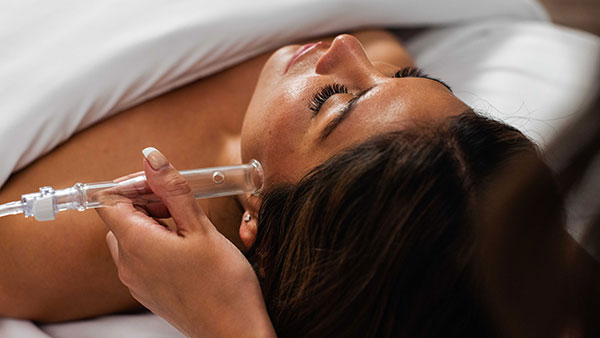 Guest receiving a high-frequency facial treatment at The Spa at Gervasi Vineyard, highlighting advanced skincare services in a soothing spa room.