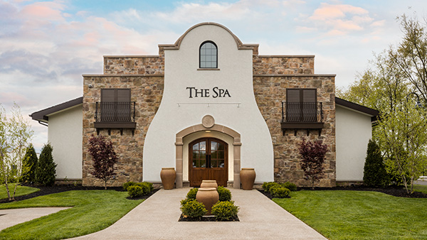 Exterior view of The Spa at Gervasi Vineyard, featuring elegant Mediterranean-style architecture and a grand front entrance flanked by planters.