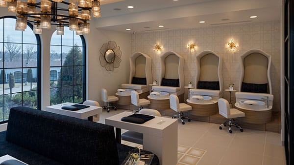 Elegant nail and pedicure salon inside The Spa at Gervasi Vineyard with custom seating and natural light from arched windows.