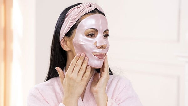 Woman applying a rejuvenating sheet mask as part of a fall facial treatment at The Spa at Gervasi Vineyard in Canton, Ohio.