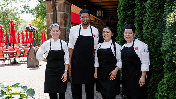 Gervasi Vineyard culinary team smiling in chef uniforms outside the Piazza patio