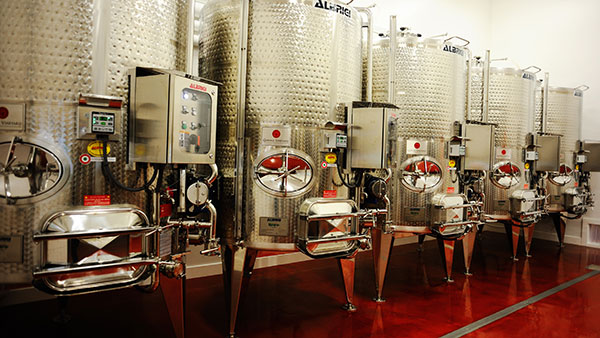 A row of stainless steel wine fermentation tanks inside Gervasi Vineyard’s winery production facility.